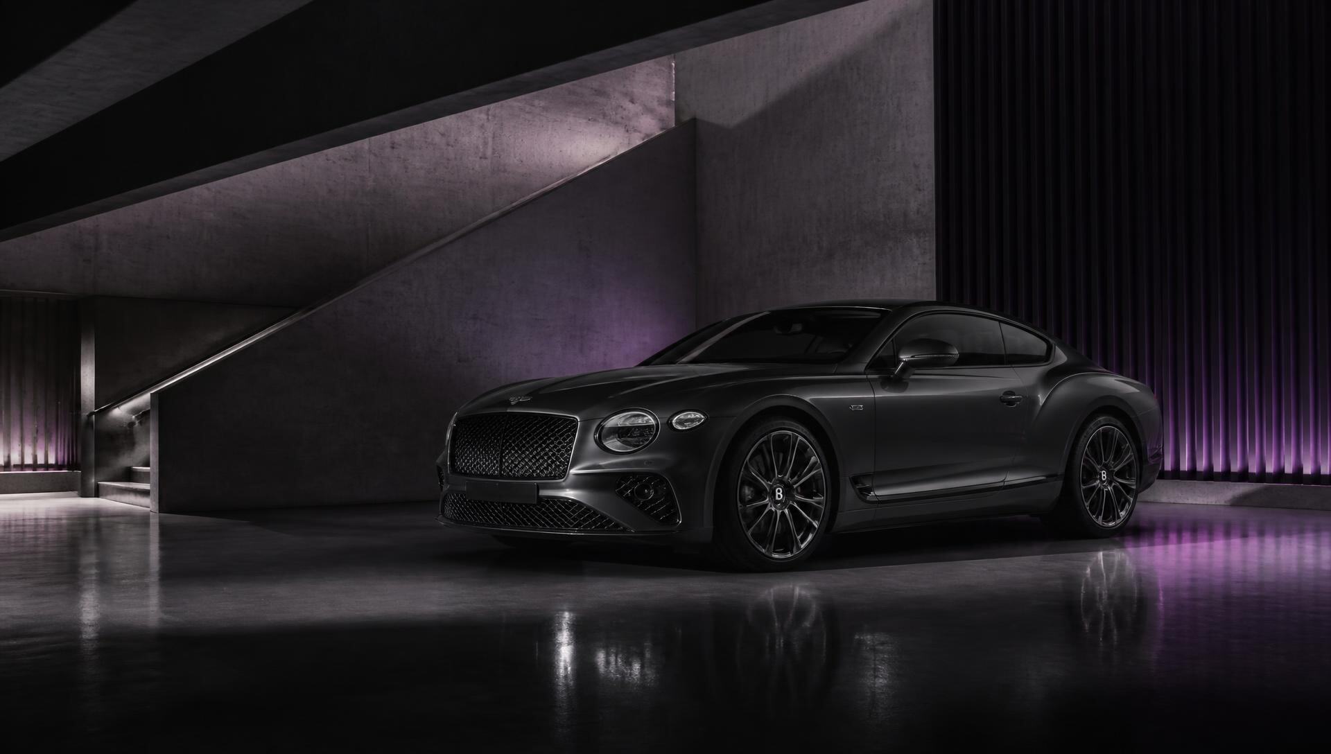 A dark luxury grand tourer coupe lit by violet light in a concrete showroom